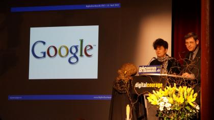 Rena Tangens und padeluun am Redner.innenpult. Im Hintergrund das Google-Logo.