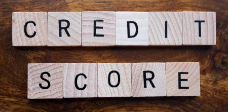 Das Wort "Credit Score" aus kleinen Holztäfelchen gelegt.