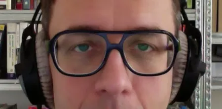 Hans Hübner mit Brille und Kopfhörern.