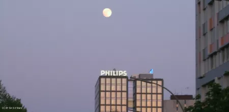 Verwaltungsgebäude der Philips GmbH in Hamburg. Der Himmel ist dämmernd, der Mond scheint.