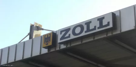 Detailaufnahme einer Zollstation mit dem Hinweisschild „Zoll“.