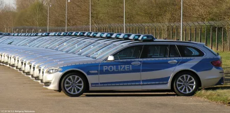 Etliche Polizeiautos stehen in einer Reihe (seitliche Ansicht).