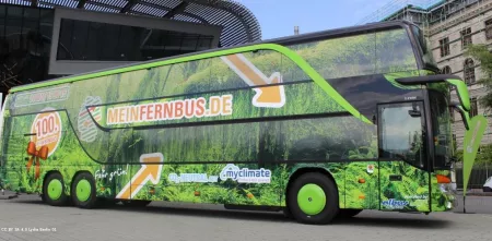 Seitenansicht eines MeinFernbus-Busses (Werbung mit viel grün und orangenem Logo).