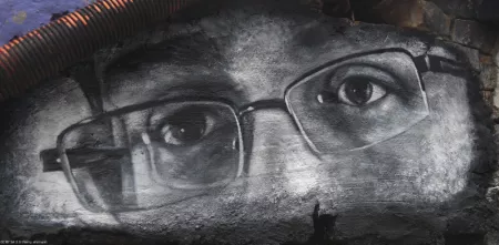 Graffiti in schwarz-weiß von Edward Snowdens Augen. Er trägt eine kantige Brille.
