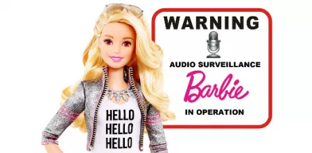 Eine Barbie mit blonden Haaren. Rechts daneben ein Warnschild: „Warning! Audio surveillance. Barbie in operation.“
