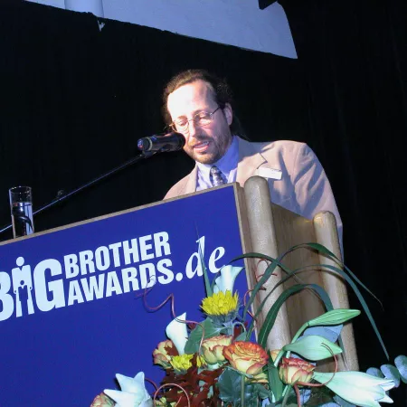 Werner Hülsmann am Redner.innenpult der BigBrotherAwards 2004.