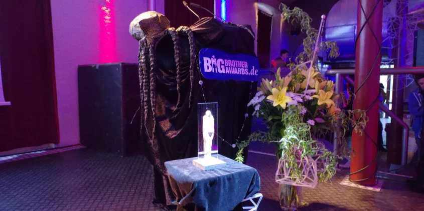 Bühnenbild der BigBrotherAwards 2017 mit einer angestrahlten BBA-Statue.