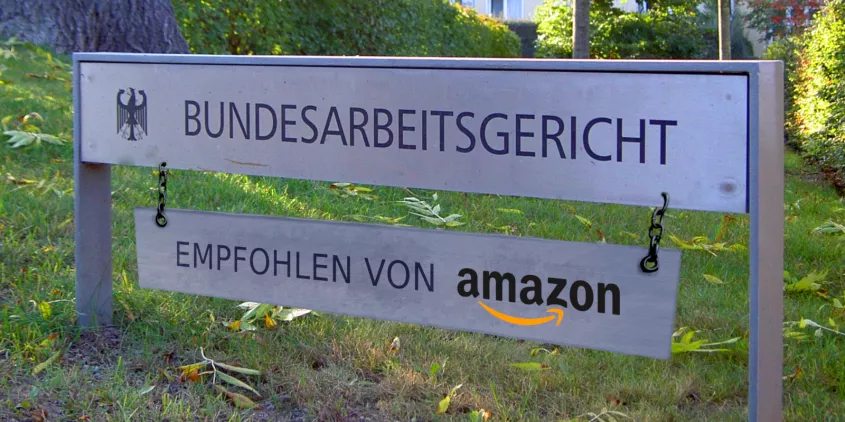 Fotomontage: Schild des Bundesverfassungsgericht. Darunter ein weiteres Schild montiert mit der Aufschrift: „Empfohlen von Amazon“.