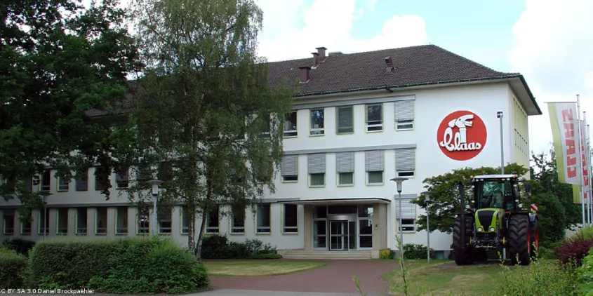 Hauptgebäude der Firma Claas mit einem Traktor davor.