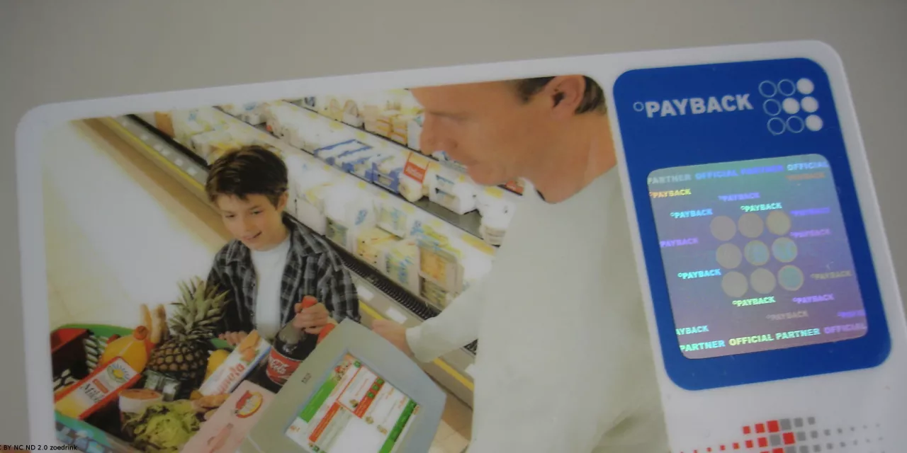 Payback-Karte im Checkkartenformat. Darauf ein Bild eines Mannes und Kindes mit einem vollen Einkaufswagen.