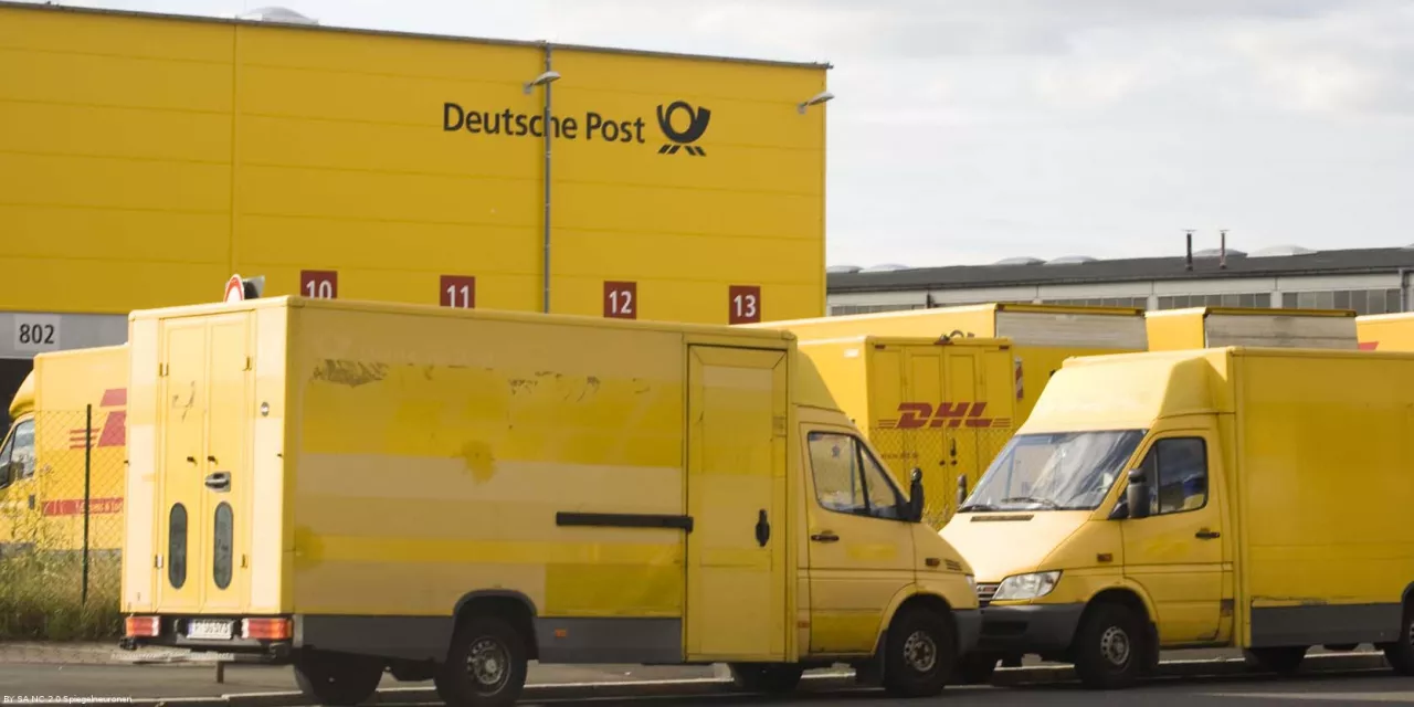 Mehrere Transporter der Deutschen Post vor einem Logistikzentrum.