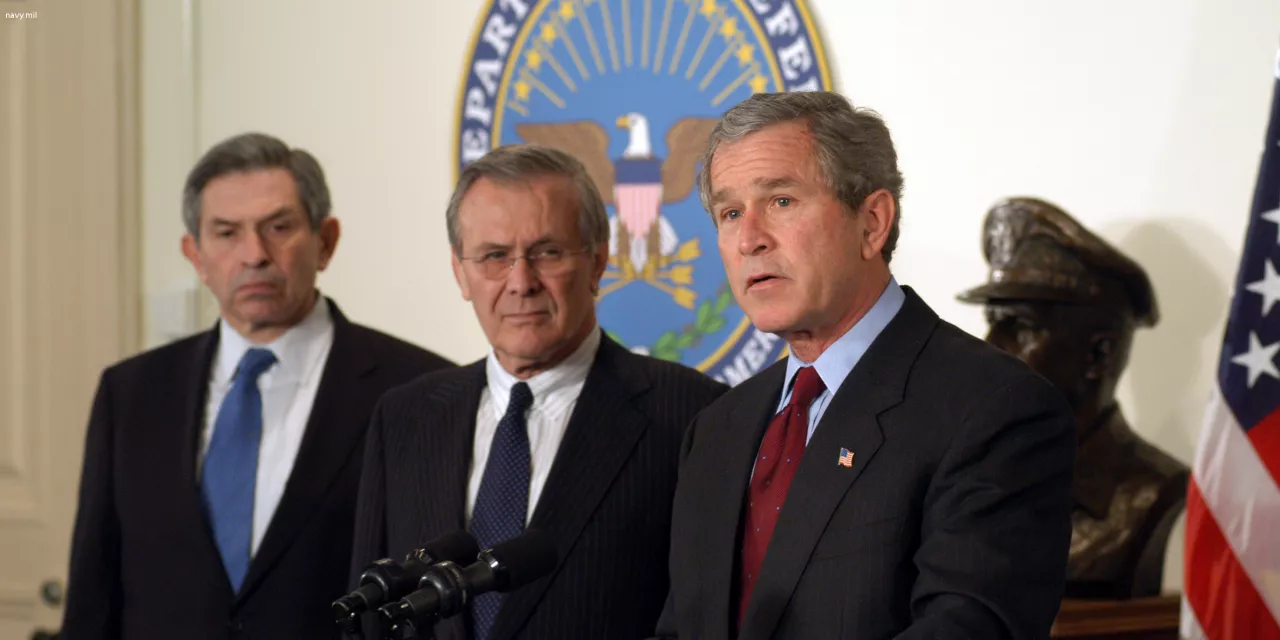 George W. Bush neben zwei weiteren Person in der Seitenansicht.