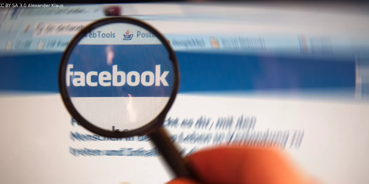 Eine Lupe, die das Facebook-Logo auf der Website vergrößert darstellt.