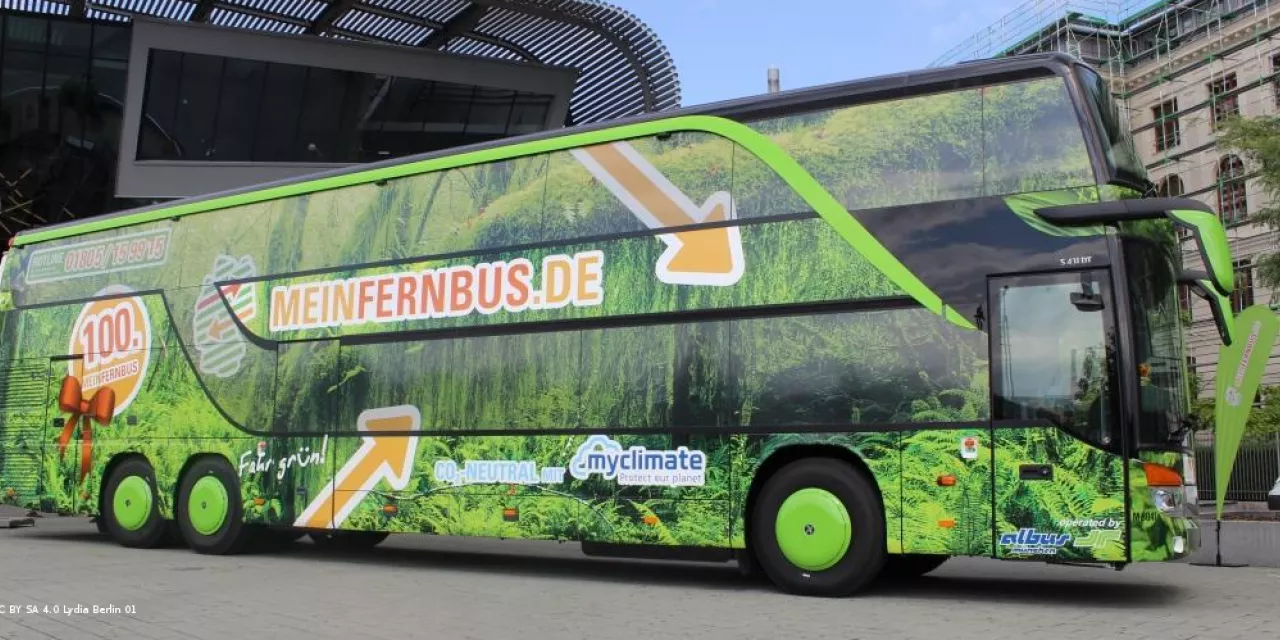 Seitenansicht eines MeinFernbus-Busses (Werbung mit viel grün und orangenem Logo).