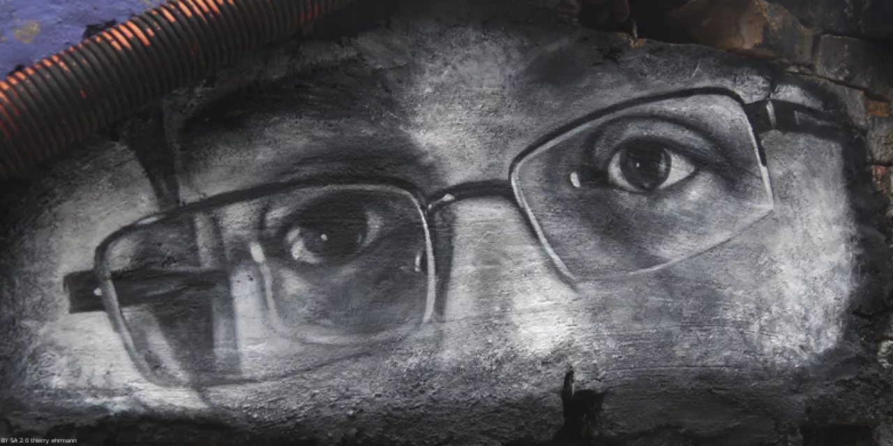 Graffiti in schwarz-weiß von Edward Snowdens Augen. Er trägt eine kantige Brille.