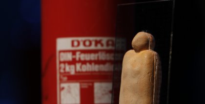 Detailaufnahme der BBA-Statue, im Hintergrund ein Feuerlöscher als Dekoration.