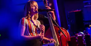 Kristin Shey am Mikrofon während einer musikalischen Darbiertung.