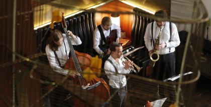 Eine Jazzband im Foyer des Stadttheaters mit Trompete, Saxofon, Kontrabass und Schlagzeug.