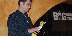 padeluun auf der Bühne im Bunker Ulmenwall mit einem Pinguin-Stofftier in der Hand.