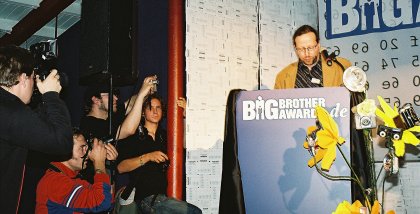 Die Presse fotografiert Werner Hülsmann am Redner.innenpult.