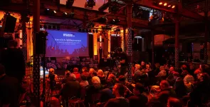 Das Publikum der BigBrotherAwards von hinten fotografiert. Blickrichtung Bühne.