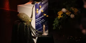 Das Redner.innenpult geschmückt mit der Datenkrake, der BBA-Statue und einem Blumenstrauß.