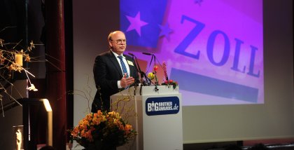 Prof. Dr. Peter Wedde am Redner.innenpult. Im Hintergrund der Schriftzug „Zoll“.