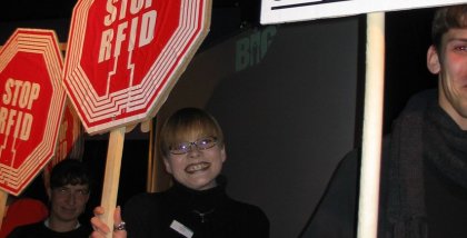 Mehrere Personen mit "STOP RFID"-Schildern in der Hand.