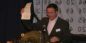 Moderator Andreas Liebold hält den Zettel für die Publikumswahl in der Hand.