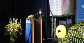 Rena Tangens am Redner.innenpult der BigBrotherAwards 2008. Im Vordergrund die Datenkrake.