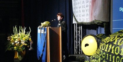 Rena Tangens am Redner.innenpult der BigBrotherAwards 2008. Im Vordergrund die Datenkrake.