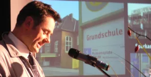 padeluun am Redner.innenpult. Im Hintergrund ein Foto einer Bushaltestelle.