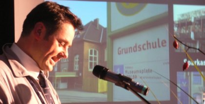 padeluun am Redner.innenpult. Im Hintergrund ein Foto einer Bushaltestelle.