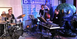 Eine Band (Schlagzeug, Kontrabass, Keyboard) performt ein Musikstück während der BBAs.
