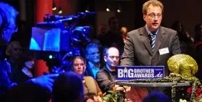 Fredrik Roggan am Redner.innenpult. Im Hintergrund das Publikum.