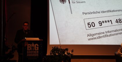 padeluun am Redner.innenpult. Im Hintergrund ein Bild eines Schreibens des Bundeszentralamts für Steuern.