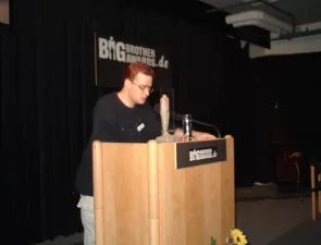 Jens Ohlig am Redner.innenpult zu den BigBrotherAwrds 2001.