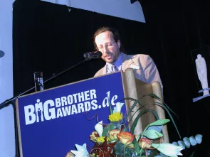 Werner Hülsmann am Redner.innenpult der BigBrotherAwards 2004.