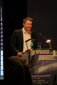 Linus Neumann am Redner.innenpult der BigBrotherAwards 2015.